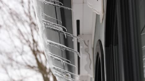 Panning-Shot-Of-Icicles-Melting-Off-Roof-In-4K