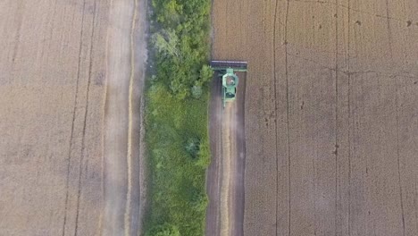Aerial-View-Flying-Over-Combine-Harvester-Harvesting-At-Sunset-In-Slow-Motion