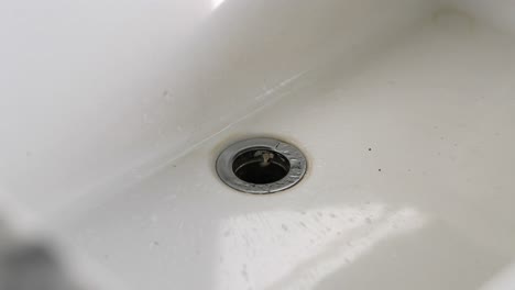 Close-Up-Of-Water-Dripping-Into-Bathroom-Sink-In-4K