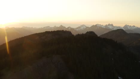 Epic-scenery-of-Kachess-mountain-ridge-during-sunset,-large-distant-peaks,-Washington,-USA,-rising-aerial