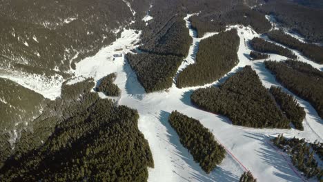Breathtaking-Aerial-Above-Ski-Resort-Slope-Paths-in-Snowy,-Winter-Landscape