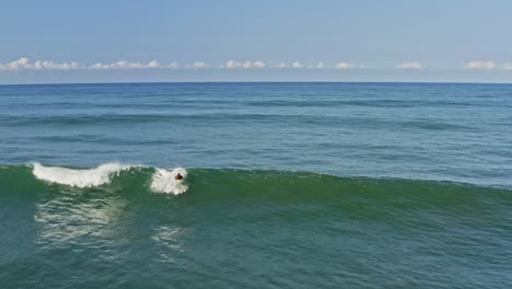 Surfista-Experimentado-Atrapando-Y-Montando-Olas-Hermosas,-Vista-Aérea