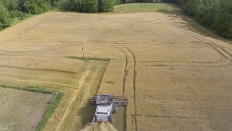 Aerial-View-Flying-Over-Combine-Harvester-In-Rural-Countryside-In-Slow-Motion