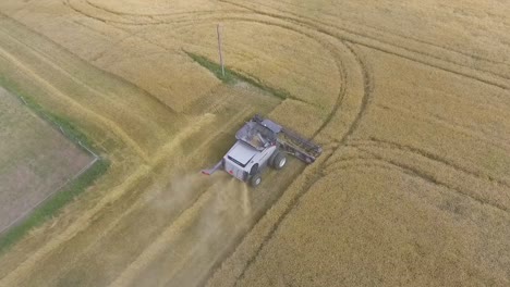 Aerial-View-Circling-Over-Combine-Harvester-In-Rural-Countryside-In-Slow-Motion