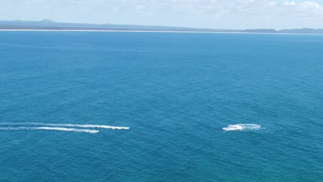 Aerial-view-of-Boats-and-Jet-skis-playing-in-the-ocean