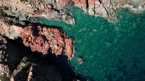 Blaue-Wellen,-Die-Im-Sommer-In-Sardinien,-Italien,-An-Roten-Felsen-An-Der-Smaragdküste-Krachen