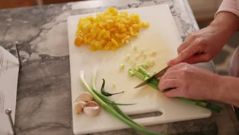 Woman-Cutting-Green-Onions-On-Chopping-Board-In-Slow-Motion