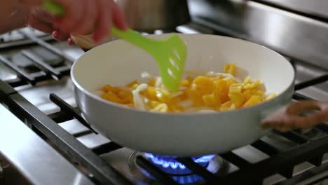 Woman-Stirring-Frying-Pan-Filled-With-Onions-And-Peppers-In-Slow-Motion
