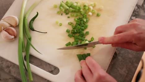 Top-Down-View-Of-Woman-Cutting-Green-Onions-In-Slow-Motion