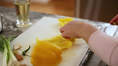 Woman-Preparing-Food-And-Cutting-Peppers-On-Cutting-Board-In-Slow-Motion
