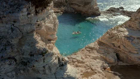 Aerial-Reveal-of-People-on-Boat-in-Beautiful-Ocean-Lagoon-in-Greece