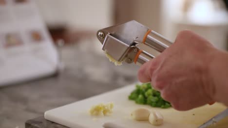 Close-Up-Of-Woman-Using-Garlic-Press-In-Slow-Motion