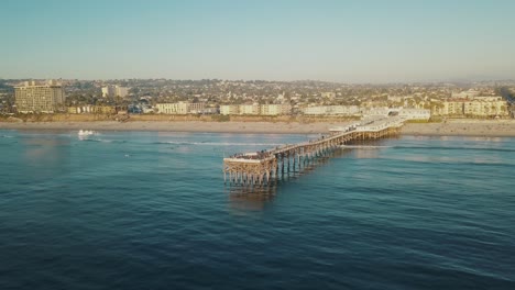 Aerial-view-of-the-"Crystal-Pier"-or-"Pacific-Beach-Pier"-in-San-Diego-California-on-a-warm-and-sunny-day-with-blue-sky-at-Pacific-Beach---4k