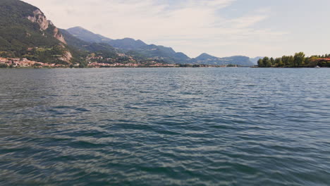 Filmflug-über-Das-Blaue-Wasser-Des-Comer-Sees-In-Italien-Mit-Bergen-Und-Bewölktem-Himmel-Im-Hintergrund---Drohnenaufnahme-Aus-Der-Luft