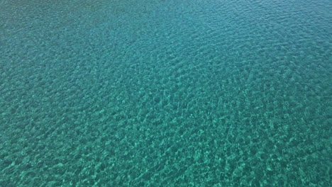 Calm-Blue-Tropical-And-Crystal-Clear-Water-Of-The-Sardinian-Sea-During-Summer-In-Sardinia,-Italy---aerial-drone-shot