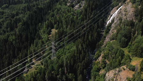 Torre-De-Transmisión-Cerca-De-La-Cascada-Entre-El-Bosque-Verde-Y-La-Montaña-Alpina-En-Val-D&#39;aosta,-Italia