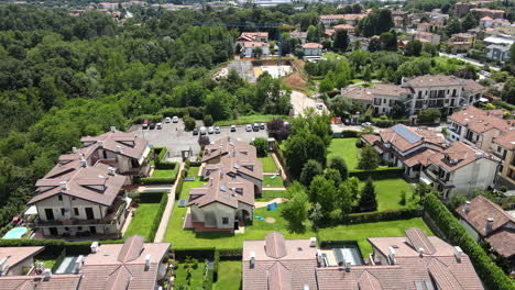 Vista-Panorámica-De-Casas-Adosadas-Con-Jardines-Verdes-Durante-Un-Día-Soleado-De-Verano-En-El-Norte-De-Italia---Toma-Aérea-De-Drones