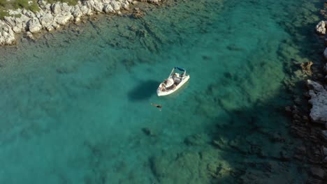 Tourists-on-Greece-Vacation-Swimming-by-Boat-in-Ionian-Sea-Island-of-Paxos