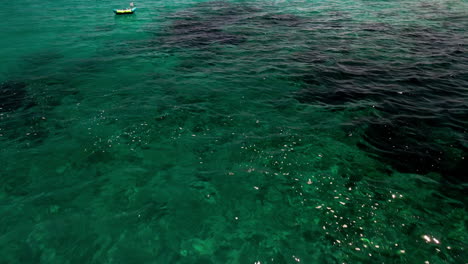 Blaugrünes-Meer-Mit-Festgemachten-Booten-Im-Sommer-In-Sardinien,-Italien---Luftdrohnenaufnahme