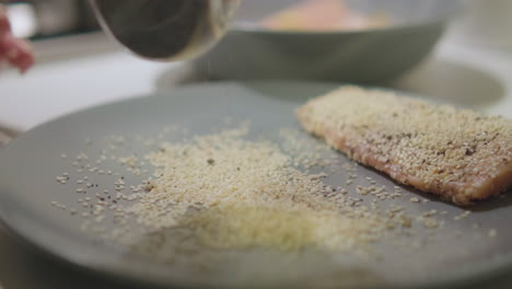 Chef-Sprinkling-Poppy-And-Sesame-Seeds-On-Plate-For-Salmon-Fish