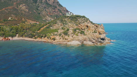 Malerischer-Blick-Auf-Das-Türkisfarbene-Meerwasser-Mit-Steilen-Bergklippen-Und-Felsen-An-Einem-Sonnigen-Sommertag-In-Sardinien,-Italien---Luftdrohnenaufnahme
