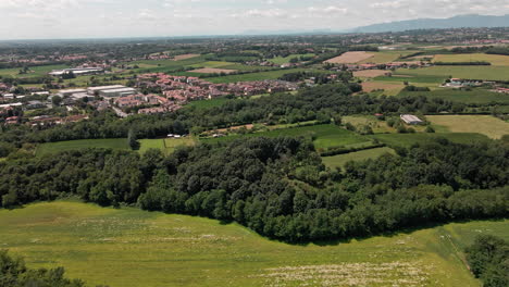Countryside-Landscape-With-Residential-Houses,-Green-Fields-And-Lush-Vegetation-In-Usmate-Velate,-Northern-Italy-On-A-Sunny-Day-Of-Summer---aerial-drone-shot