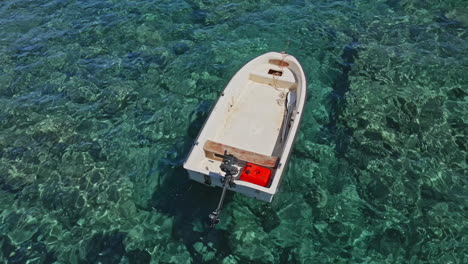Empty-Small-Boat-Moored-And-Floating-At-Crystal-Clear-Blue-Water-On-A-Sunny-Day