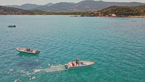 Océano-Azul-Cristalino-Con-Barcos-Navegando-En-Verano-En-Cerdeña,-Italia