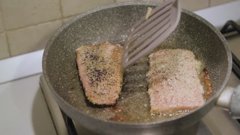 Chef-Turn-Salmon-Fillet-With-Poppy-Seeds-Cooking-In-Olive-Oil-On-Frying-Pan-Using-Spatula