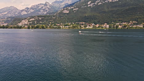 Beautiful-Lake-Como-With-Boats-Sailing-During-Sunny-Day-Of-Summer-In-Northern-Italy---aerial-drone-shot