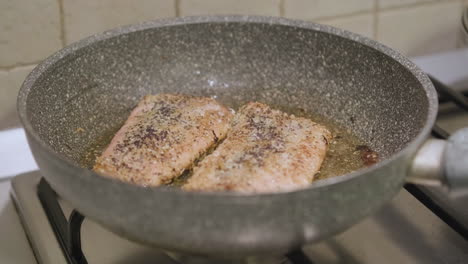 Lachsfischfleisch-Auf-Heißem-Olivenöl-In-Der-Pfanne-Kochen,-Zeitlupe-Schließen