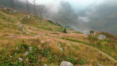Malerischer-Blick-Auf-Wiesen-In-Den-Bergalpen-Mit-Nebligem-Tal-Im-Hintergrund,-Passo-San-Marco,-Norditalien---Luftdrohnenaufnahme