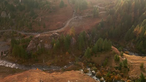 Fließt-Flussabwärts-Inmitten-Eines-Herbstlichen-Waldtals-Bei-Einem-Nebligen-Sonnenaufgang-Im-Valle-Argentera,-Italien