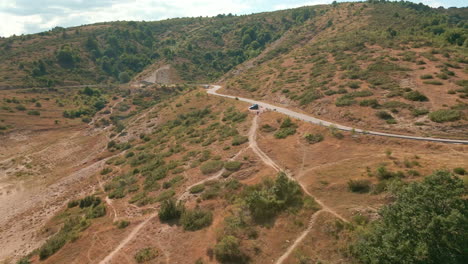 Camino-A-Través-De-Las-Montañas-Con-Vegetación-Verde-Y-Tierra-árida-En-Italia---Toma-Aérea-De-Drones