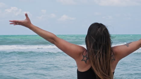 Woman-Raising-Arms-In-Front-Of-The-Ocean-At-Sunset---slow-motion