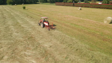 Rotary-Rake-Attached-To-A-Tractor-Windrowing-Cut-Hay-For-Drying-At-The-Farmland-In-Italy