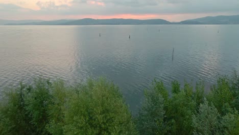 Blick-Auf-Das-Ruhige-Wasser-Des-Trasimenischen-Sees-Bei-Sonnenaufgang-In-Italien---Luftrückzug