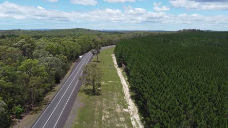 Drone-ascending-over-a-highway-and-forest