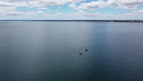Drones-Volando-Sobre-Barcos-De-Pesca-En-El-Océano,-Costa-En-El-Fondo
