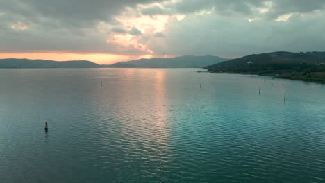 Ruhige-Landschaft-Des-Trasimenischen-Sees-Bei-Sonnenaufgang-In-Umbrien,-Italien---Luftdrohnenaufnahme