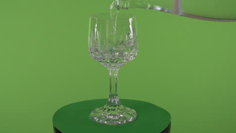 clean-tap-water-pouring-into-fancy-spinning-glass-in-front-of-chroma-green-screen