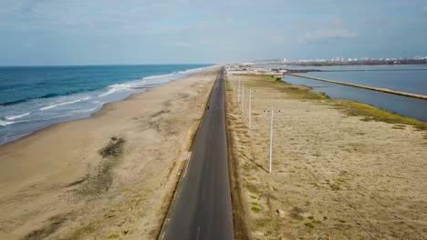 Majestic-highway-road-in-between-ocean-and-lake-water,-aerial-drone-shot