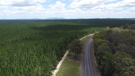Drone-descending-over-empty-highway-and-forest