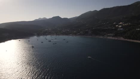 Wide-Aerial-view-of-Parga-Coastline-landscape,-Sunlight-reflected-on-sea-surface,-Greece