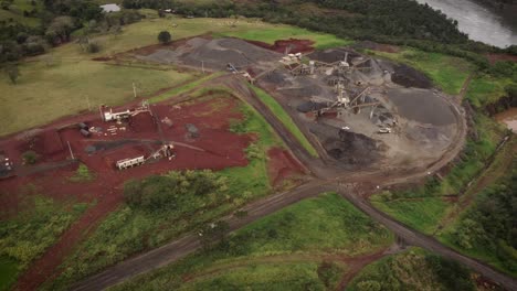 Hochrangige-Drohnenaufnahmen-Eines-Tagebau-Steinbruchs-In-Brasilien-Neben-Dem-Iguazu-Fluss,-Wo-Eine-Lastwagenladung-Mit-Steinen-Abfährt