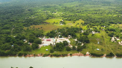 Hochfliegende-Drohnenaufnahme-Mit-Blick-Auf-Ein-Kleines-Dschungeldorf-In-Der-Nähe-Eines-Flusses-In-Guyana