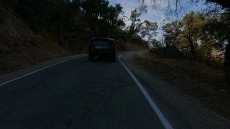 Cinematic-FPV-following-shot-of-a-police-car-driving-through-a-country-road