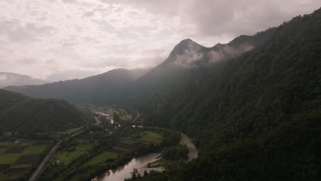 River-By-The-Lush-Green-Mountains-In-Fog
