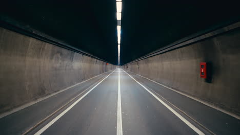 Cinematic-symmetrical-shot-of-a-long-endless-road-inside-dark-tunnel