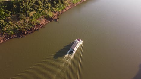 Transbordador-Turístico-Cruzando-El-Río-Iguazú-Al-Atardecer,-Frontera-Entre-Argentina-Y-Brasil